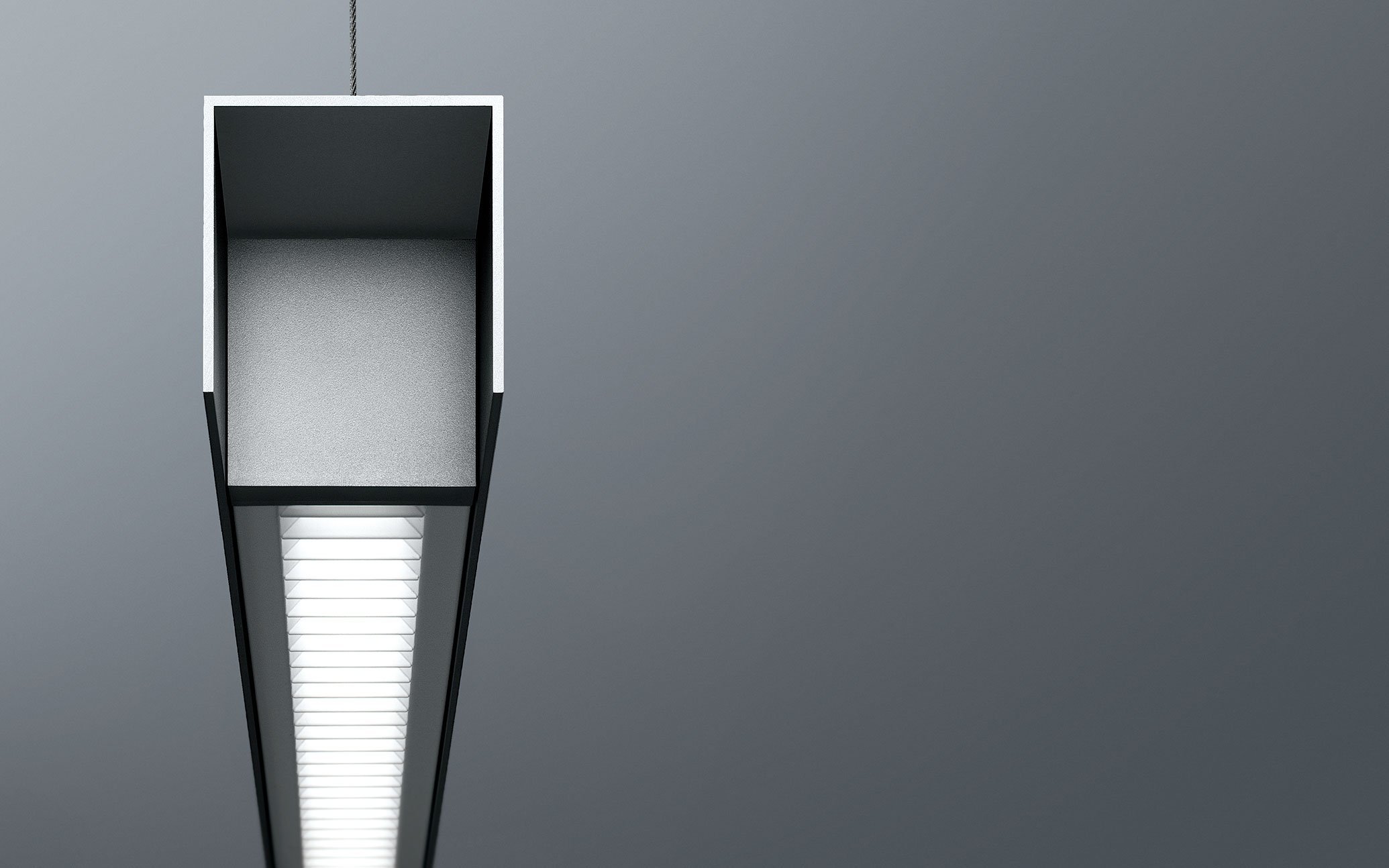 天井から吊り下げられた長い照明器具と天井の一部の画像