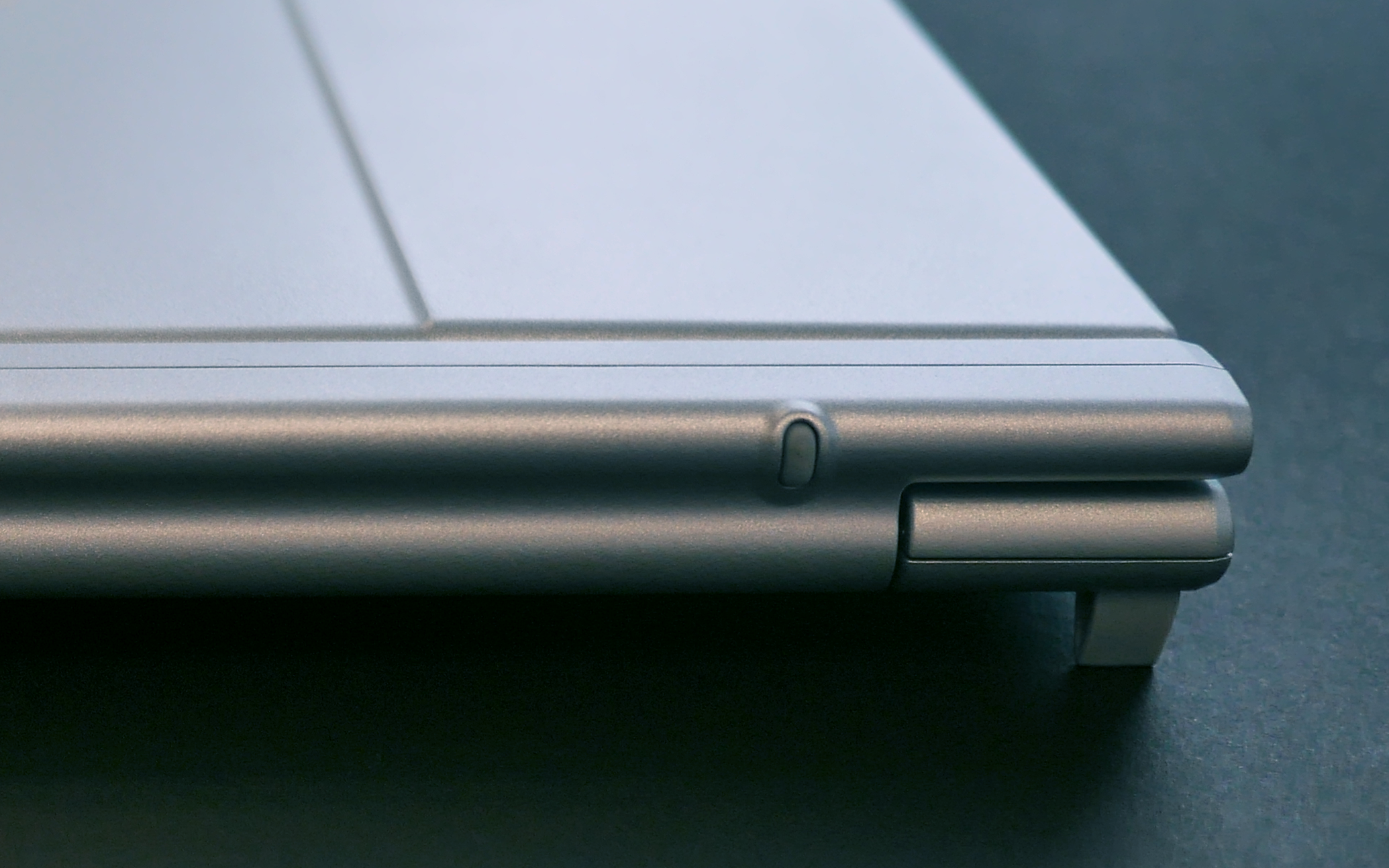 ノートパソコンの左側の角部分、金属製のシルバー色、ヒンジと閉じた状態の天板