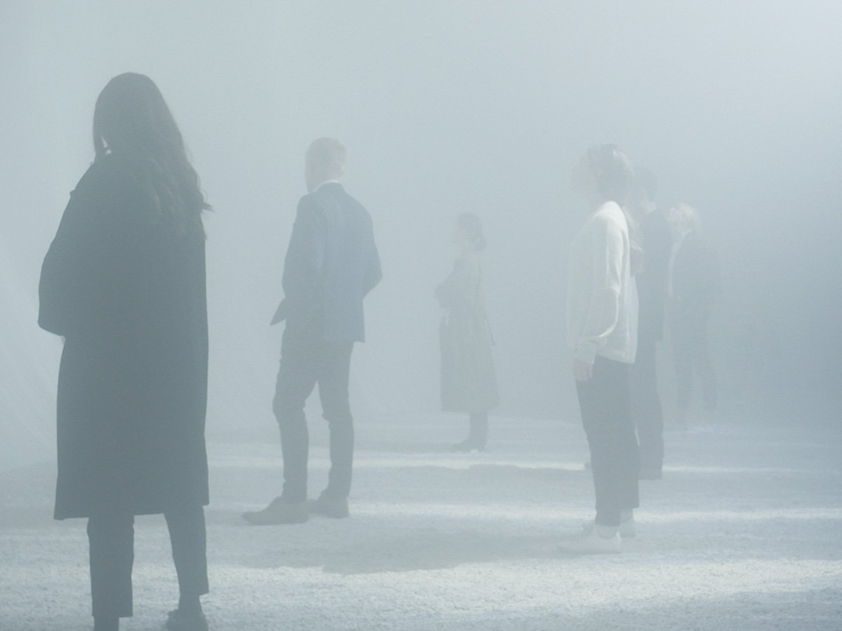 右手に白いソファとキッチンが見えている海に面した建物の室内