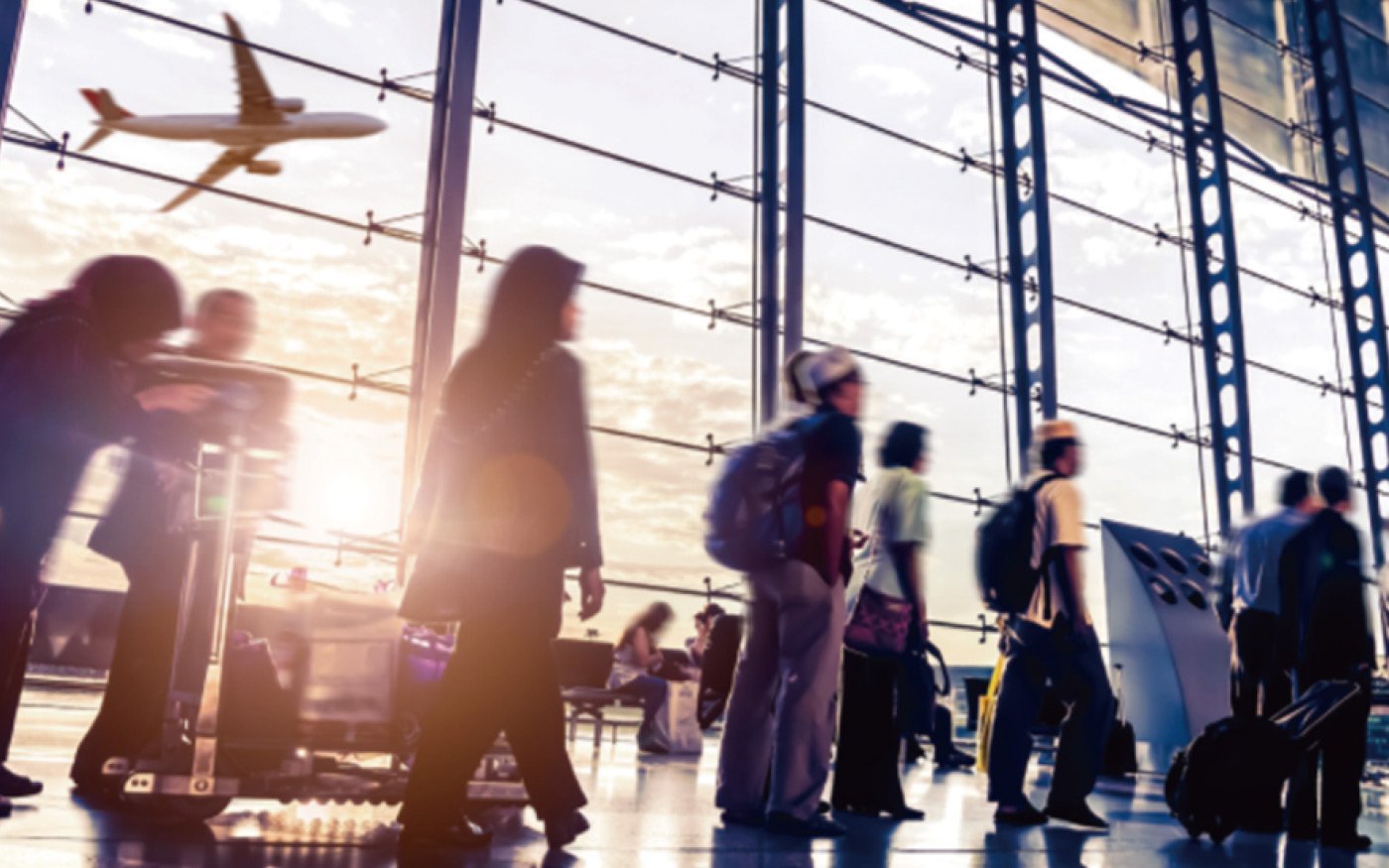 ガラス張りの空港出発ロビーで歩く複数の人物。背景に飛行機の離陸シルエット。荷物を持つ人々と椅子に座る利用客。