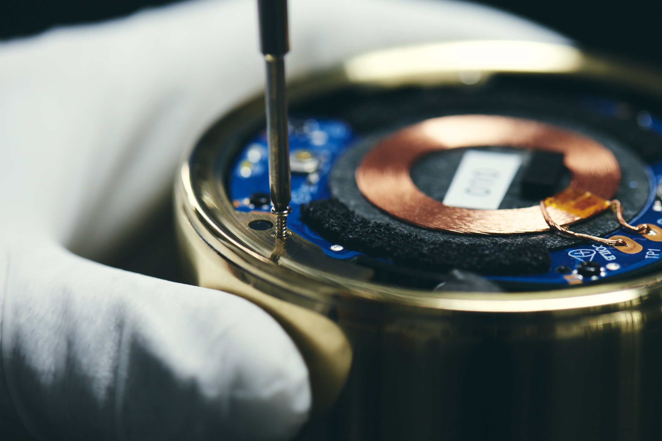 茶筒型スピーカーの内部、工具で金属部品を固定している様子