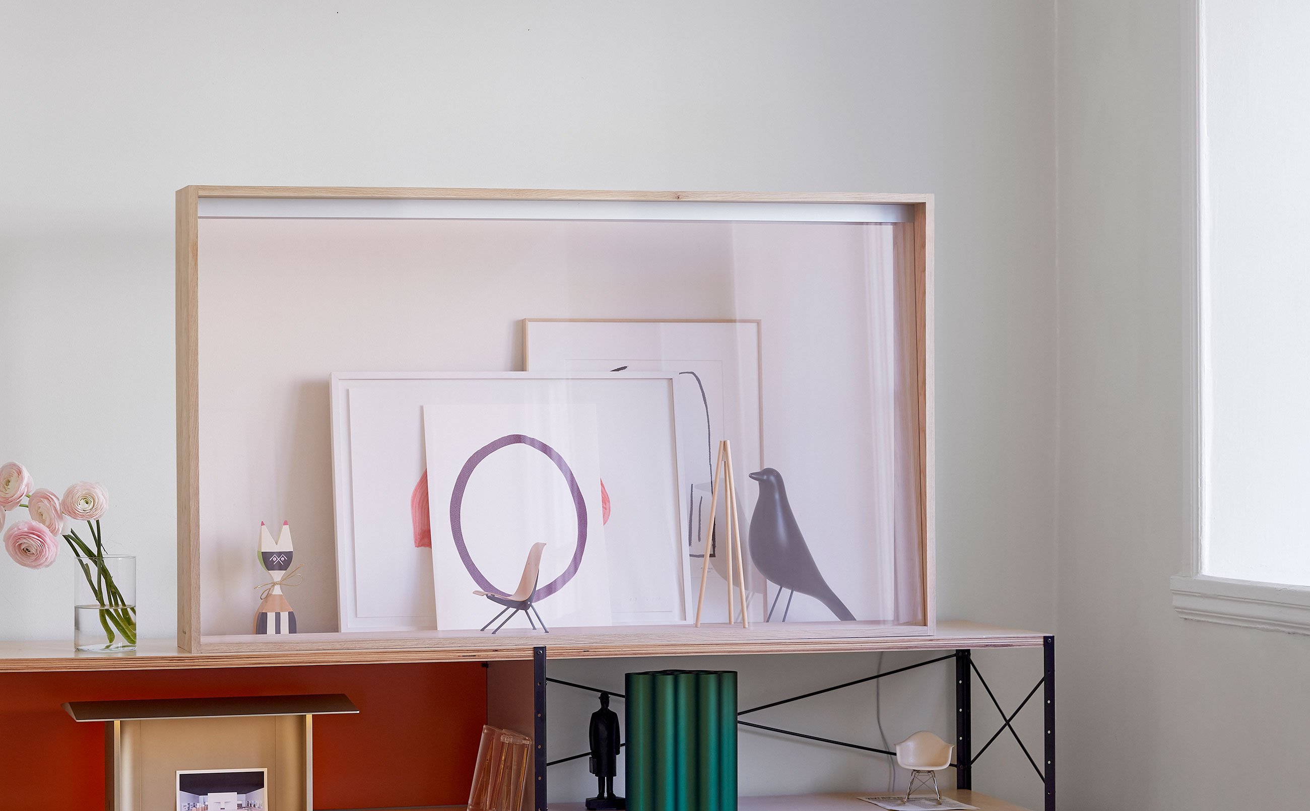 窓の光が差し込む部屋の棚の上に透明なフレームが置かれている