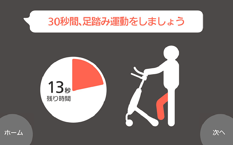 黒背景の運動指示画面。上部に赤文字で「30秒間、足踏み運動をしましょう」の表示。中央に残り13秒を示す白い円形タイマー。右側に歩行器を使用する人物の白いピクトグラム