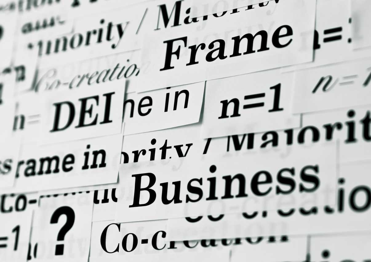 DEI、BUINESS、n=1など、一単語づつ書いた紙片が壁面に重なり合いながら貼られている