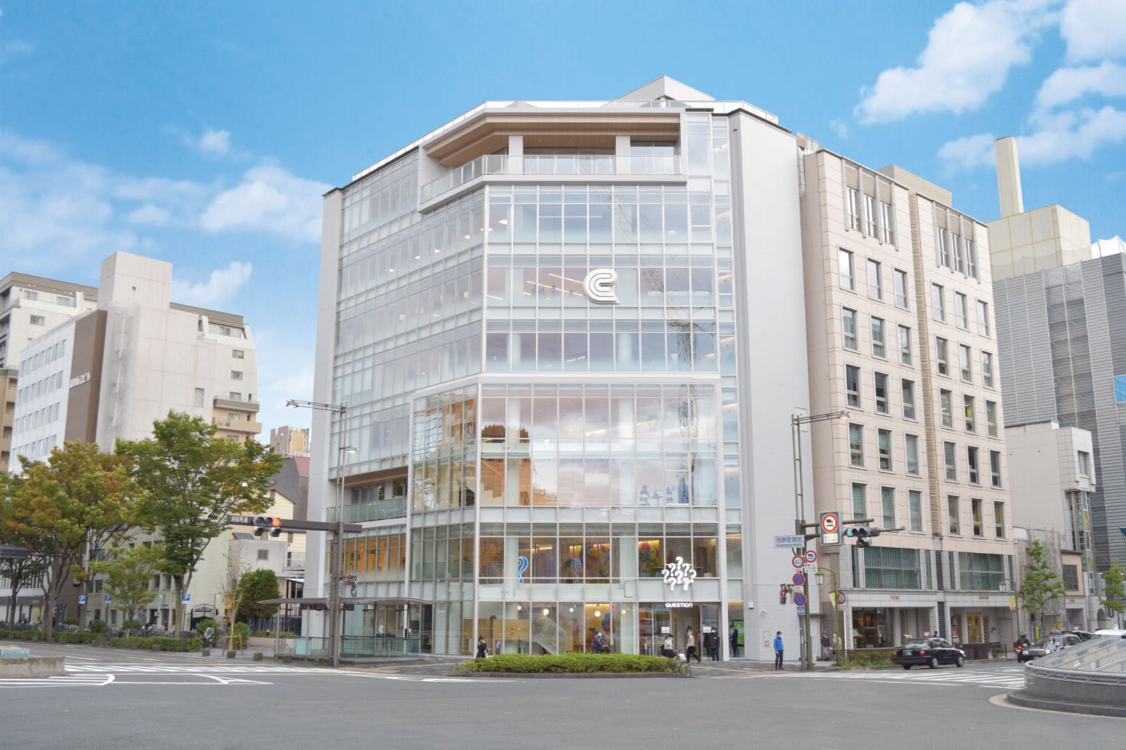 ガラス張りの多層ビル、街角に位置し交差点を見下ろす