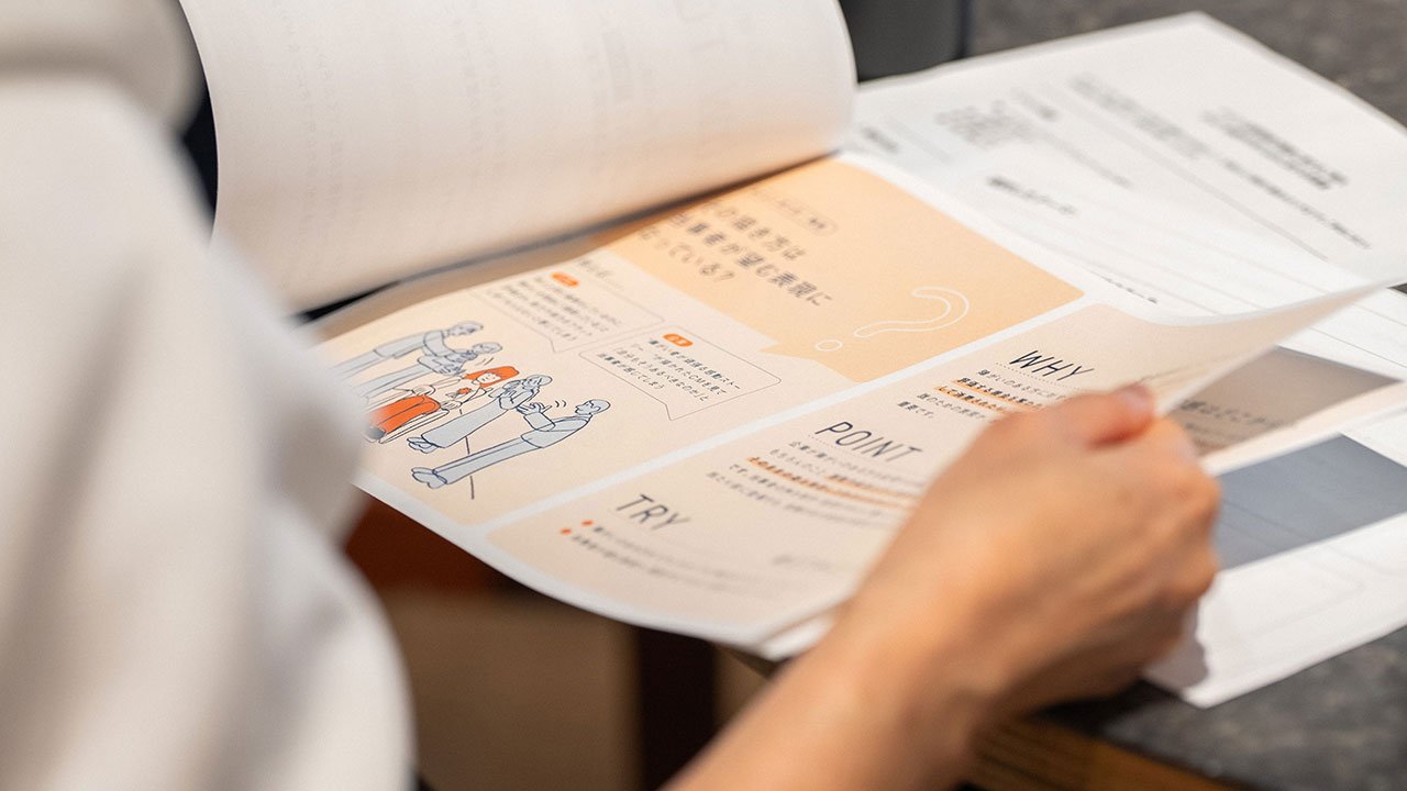 参加者の手元写真。ワークブックをめくっている。