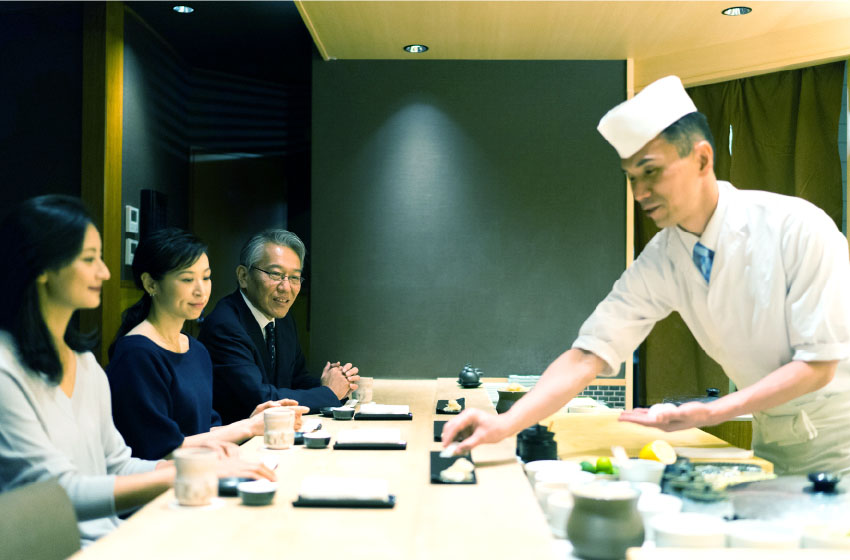 お寿司屋さんで寿司を提供している写真