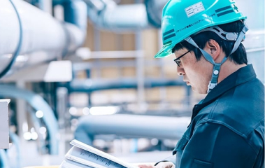 パナソニック環境エンジニアリング株式会社 プラント施設内で書類に目を通すエンジニア