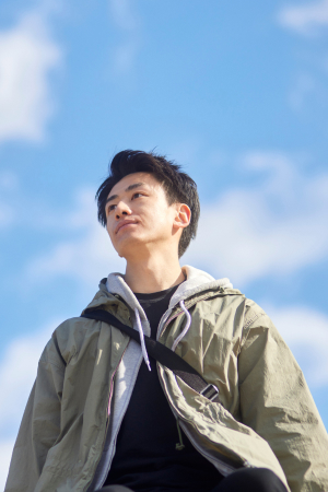 空を背景に、遠くを見上げる男性