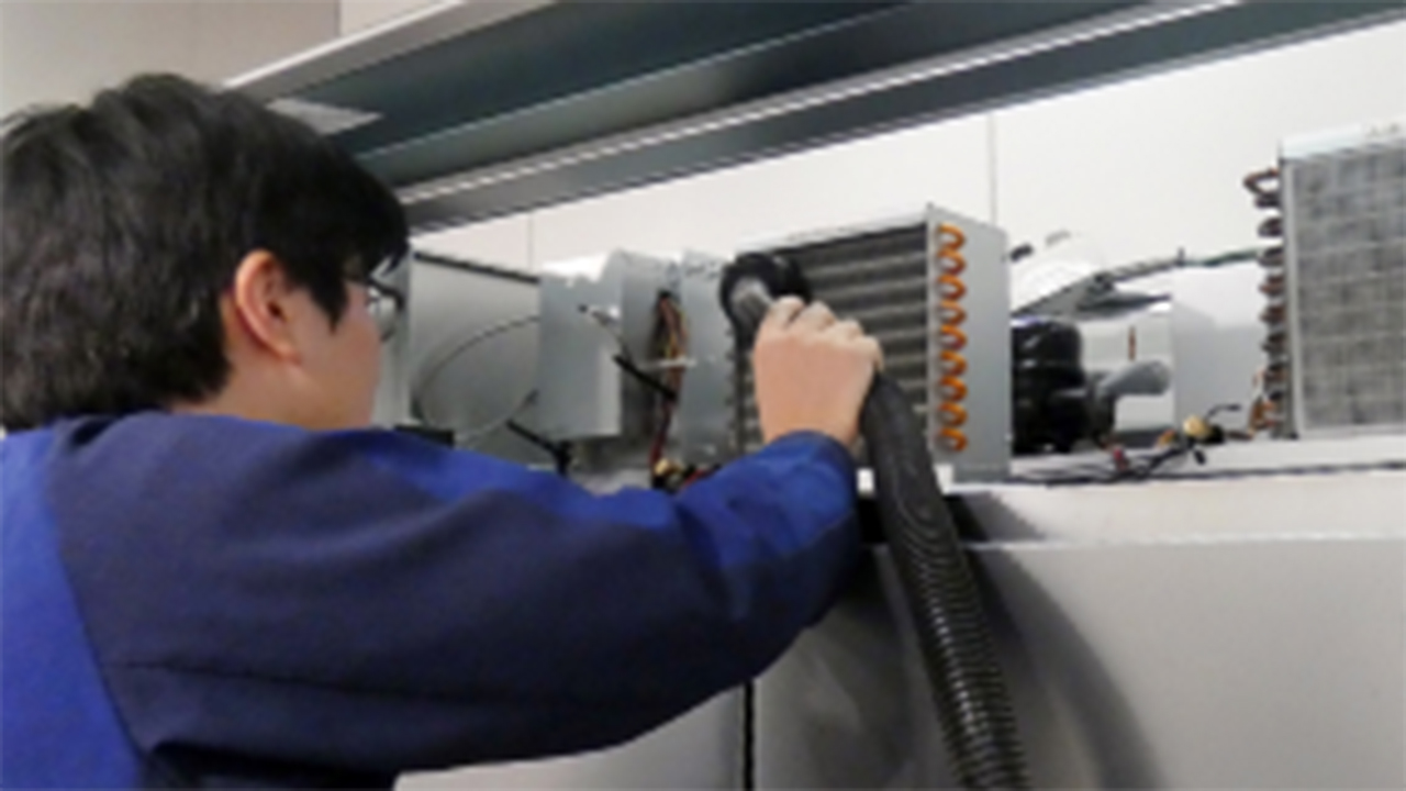 ブラシを使用してフィルターやコンデンサーの汚れを清掃する様子