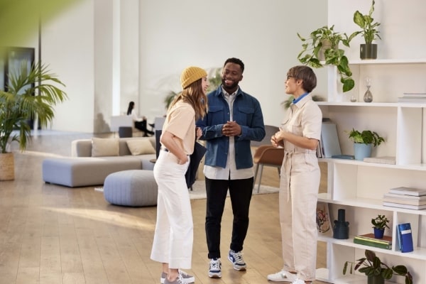 3人の男女がオフィスで会話している画像