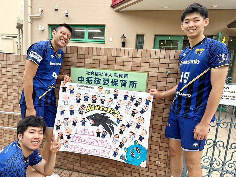 写真：中振敬愛保育所からのメッセージを掲げる大竹選手、仲本選手、西川選手