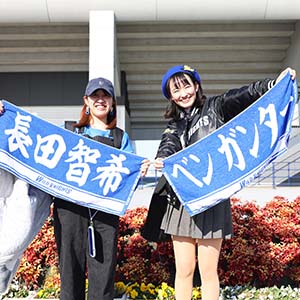 選手の名前入りタオルを持ち笑顔の女性2人組