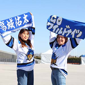 ユニフォームを着てタオルを掲げる２人の女性