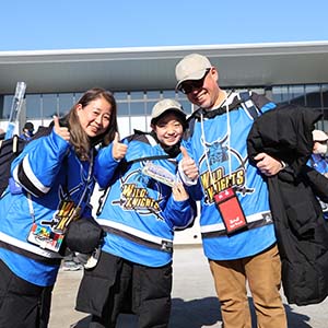 ユニフォームを着てポーズをとる男女３人