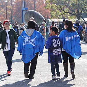 ポンチョを着た2人と少年の後ろ姿