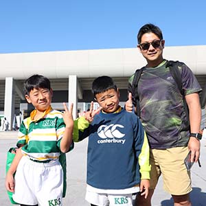 ピースサインの2人の少年と男性